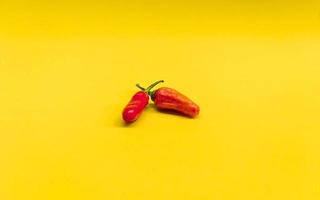 close up photo of red chili with yellow isolated background