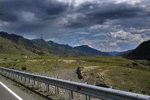 ribbon of the road among the slopes of the mountains on the expanses of Altai on a summer day photo