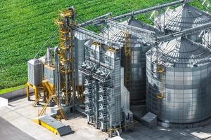 vista aérea sobre el elevador de granero de silos agrícolas en la planta de fabricación de procesamiento agrícola para el procesamiento de secado, limpieza y almacenamiento de productos agrícolas, harina, cereales y granos. foto