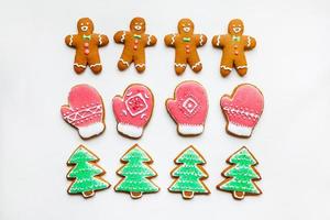 Handmade festive gingerbread cookies in the form of stars, snowflakes, people, socks, staff, mittens, Christmas trees, hearts for xmas and new year holiday on white paper background photo