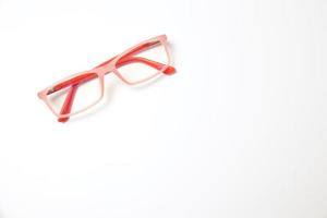 Pink eyeglasses on white photo