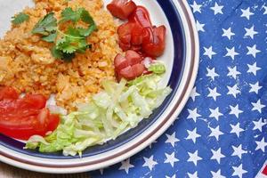 Fried rice with fried sausage served in a creamy dish with tomatoes and cucumbers. photo