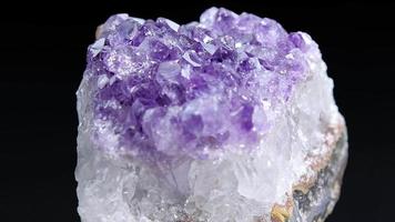 Amethyst aus nächster Nähe. Nahaufnahme eines Amethystfelsens, der sich im dunklen Hintergrund dreht. video