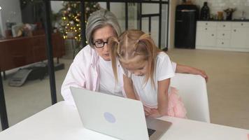 niña que usa la computadora en casa con la familia