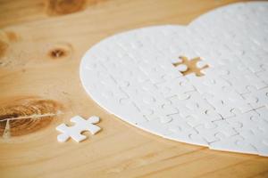 White part of jigsaw puzzle pieces on wooden table background. concepts of problem solving, business success, teamwork, Team playing jigsaw game incomplete, Texture photo with copy space for text