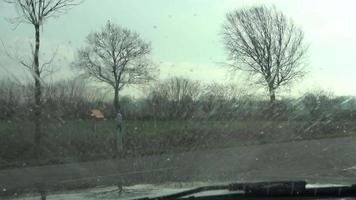 View at the windshield of a sports car from inside while the wipers cleaning the front windshield. video