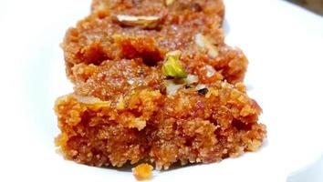 Homemade carrot halwa, traditional indian sweet, on white plate photo