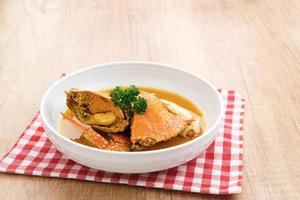 Kepiting Saus Padang, Crab with Padang Sauce, spicy and savory. Served in white bowl. photo