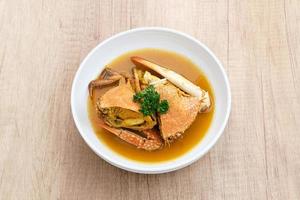 Kepiting Saus Padang, Crab with Padang Sauce, spicy and savory. Served in white bowl. photo