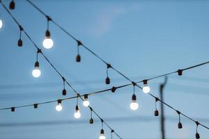 decoración de bombillas en el cielo azul en la fiesta al aire libre. foto