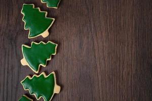 Top view of decorated Christmas tree cookie on wooden table background with copy space. photo
