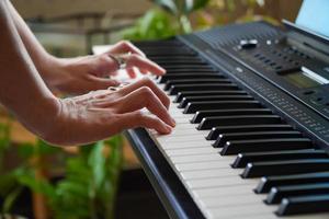 manos femeninas tocando el piano. manos humanas tocando el piano en la fiesta. mujer tocando el teclado del sintetizador foto