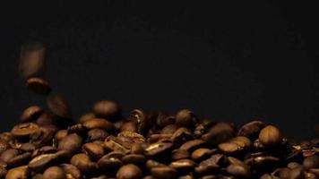 rallentatore di chicchi di caffè tostati che cadono. semi di caffè biologico. video