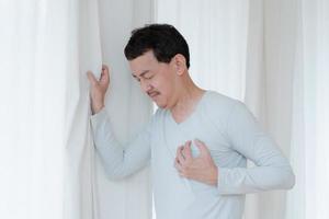 a man touching his heart, with red highlight of heart attack, and others heart disease concept, Heart attack symptom photo