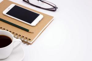 Business work place with cup of coffee on white table photo