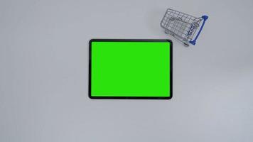 stop motion een winkelwagentje dat beweegt rond tablet groen scherm. video