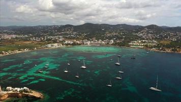 Überflug von Yachten und Booten im offenen Wasser der Küste von Ibiza, grüne Hügel im Hintergrund video