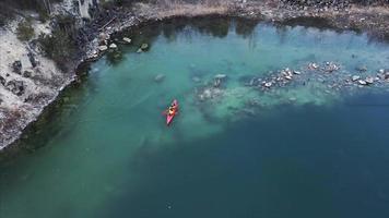 gente en kayak naranja remando en cantera de roca inundada video