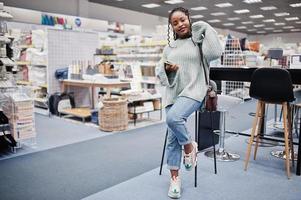 African woman choosing the right furniture for her apartment in a modern home furnishings store. photo