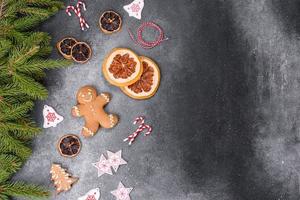 Gingerbread, Christmas tree decorations, dried citrus fruits on a gray concrete background photo