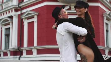 Young hip couple with tattoos embrace on a city street video