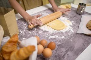 El primer plano de una joven hermosa mujer está horneando en su negocio de cocina, panadería y cafetería. foto