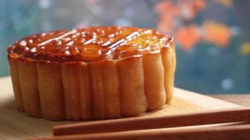 Mooncake on wooden platter board with river background. Traditional Mid-autumn Festival celebration Chinese food. photo