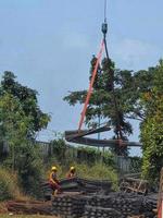 Two construction workers are mobilizing pieces of structural steel. This process is carried out with the help of cranes and slings. photo