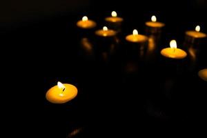 Many candles burn with a shallow depth of field. photo