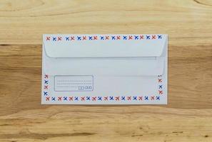Envelope by air mail isolated on wood photo