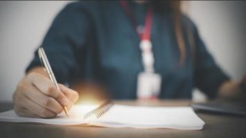 Business Woman Writing with pen in notepad photo