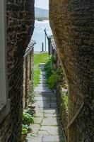 una vista del mar a través de un estrecho callejón en stromness, orkney. foto