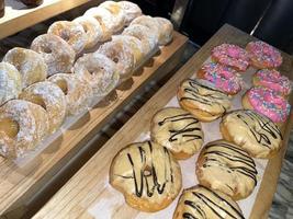 Lines of fresh delicious donuts on bakery shop, tasty multiple donuts, Selective focus donuts photo