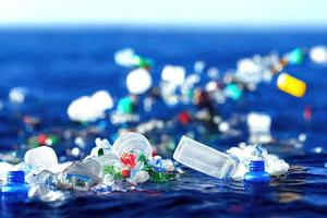 Botellas de plástico problemáticas y microplásticos flotando en el océano. foto