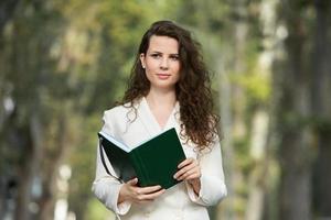 Portrait of a business woman with a notebook in her hand.  Smartly dressed girl outside. Successful white european woman photo