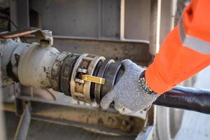 A man works in an oil field and is using oil pipes to refuel. photo