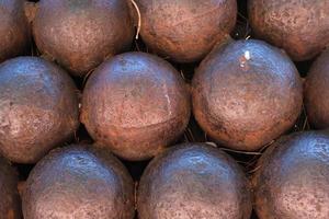 cierre de balas de cañón antiguas y oxidadas, patrón, textura de bala de cañón con forma de esfera de hierro, una pila de bolas de metal redondas, munición de guerra, fondo. foto