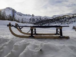 trineo de madera en la nieve en dolomitas foto