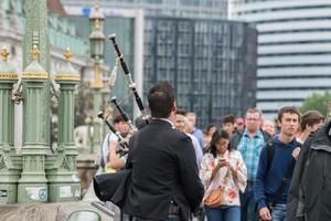 Londres, Inglaterra - 15 de julio de 2017 - hombre jugando cornamuse en el puente de Londres foto