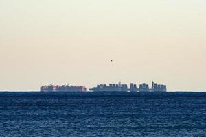 Big ship mirage on sea horizon line photo