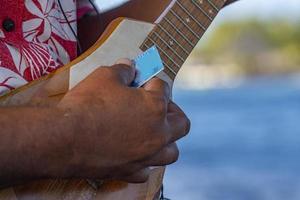 old man hands playing hukulele in french polynesia photo