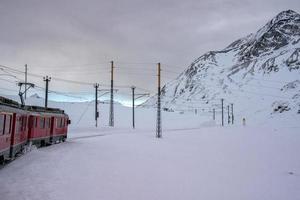 Red train in the snow in swiss alps photo