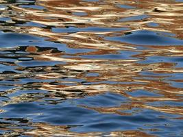 reflejos anaranjados en el mar azul como pintura foto