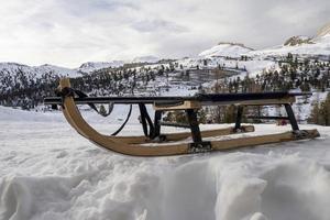 trineo de madera en la nieve en dolomitas foto