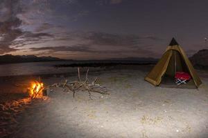 campamento de tiendas en la playa de arena del desierto en california por la noche foto