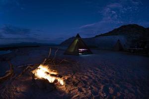 campamento de tiendas en la playa de arena del desierto en california por la noche foto