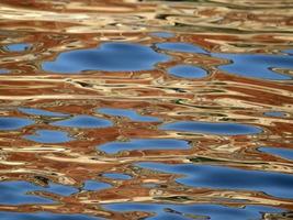 reflejos anaranjados en el mar azul como pintura foto