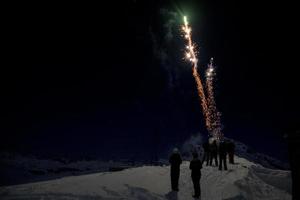 feliz año nuevo y feliz navidad fuegos artificiales sobre fondo de nieve de montaña foto