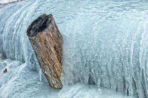 Frozen creek small waterfall in winter time photo