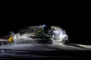 moto de nieve en pista de esquí por la noche foto